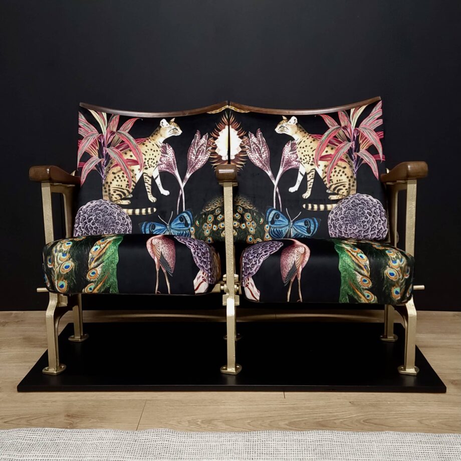 Two cinema seats in a black patterned velvet with flowers and animals