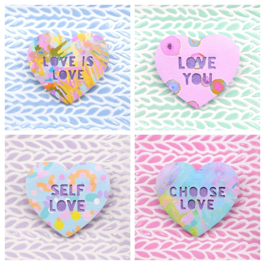 Colourful, pastel, handmade brooches with phrases like Love is Love, Love You, Self Love and Chooses Love