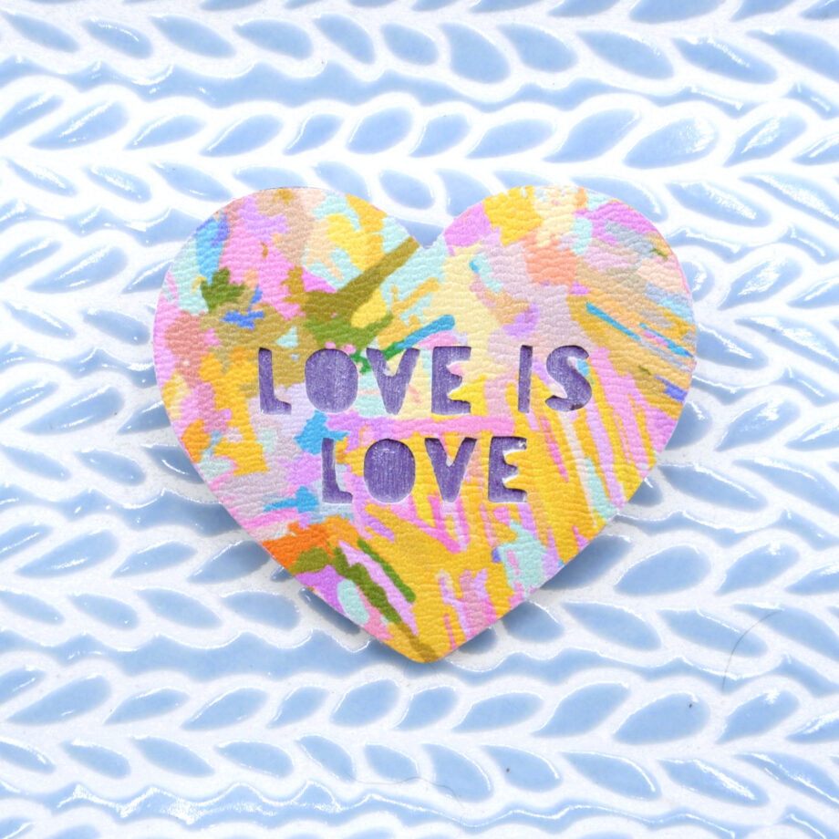 Handmade abstract art brooch with the LGBTQ phrase Love is Love cut from it