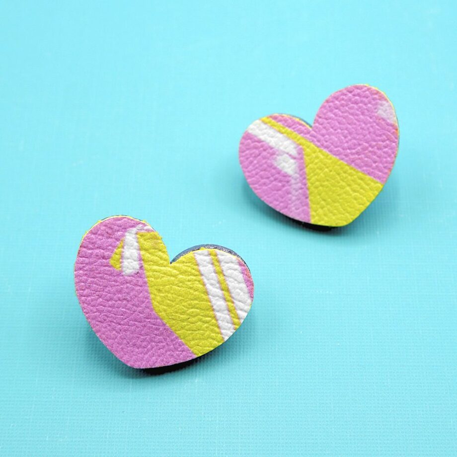 Unique set of handmade heart-shaped earrings with a pastel pink and yellow abstract design.