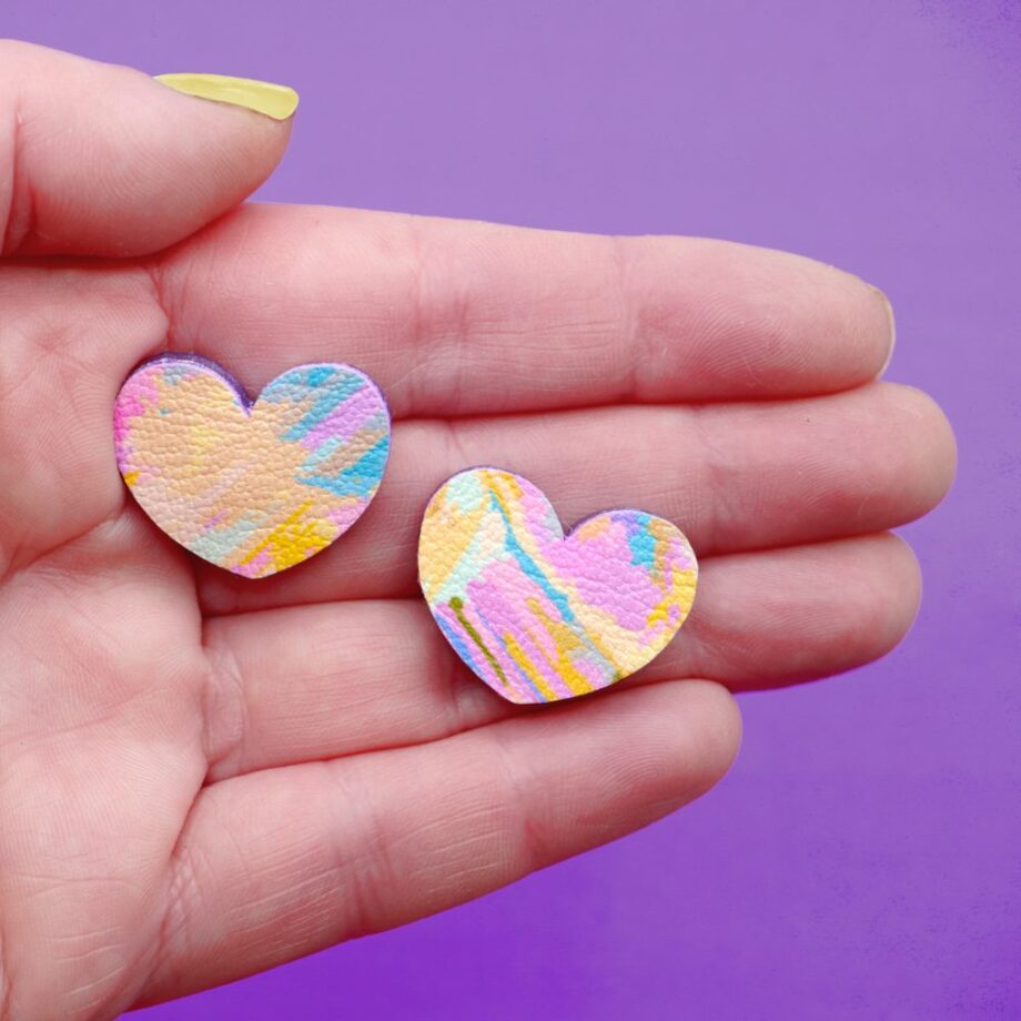 Pair of pastel pink, yellow, and blue abstract heart earrings.