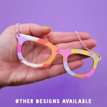 Vibrant, pop art glasses necklace in a bold pink, orange, purple and yellow geometric design.