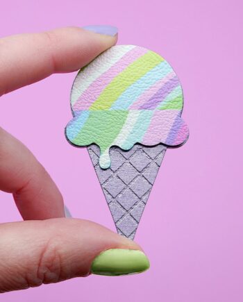 A pastel coloured ice cream brooch held in fingertips with pastel painted nails. A playful handmade accessory with a fun geometric design