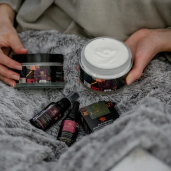 Pink Prestige whipped shea butter displayed with other skincare products on soft grey velvet fabric, styled as a luxurious self-care gift set.