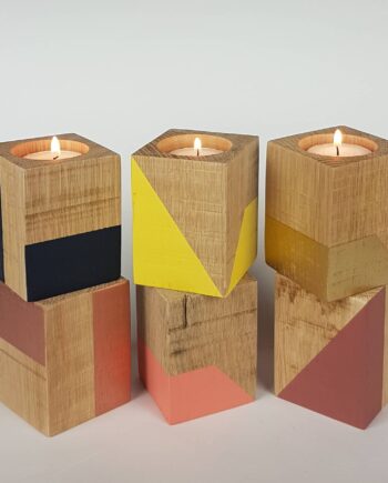 Group of tall wooden tealight holders with coloured geometric shapes