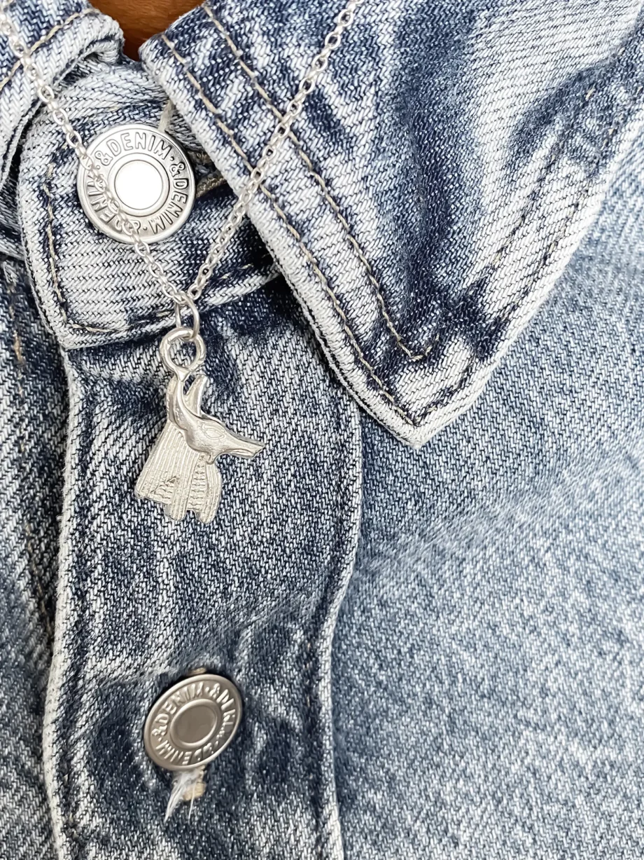 Silver Anubis pendant worn on a denim jacket