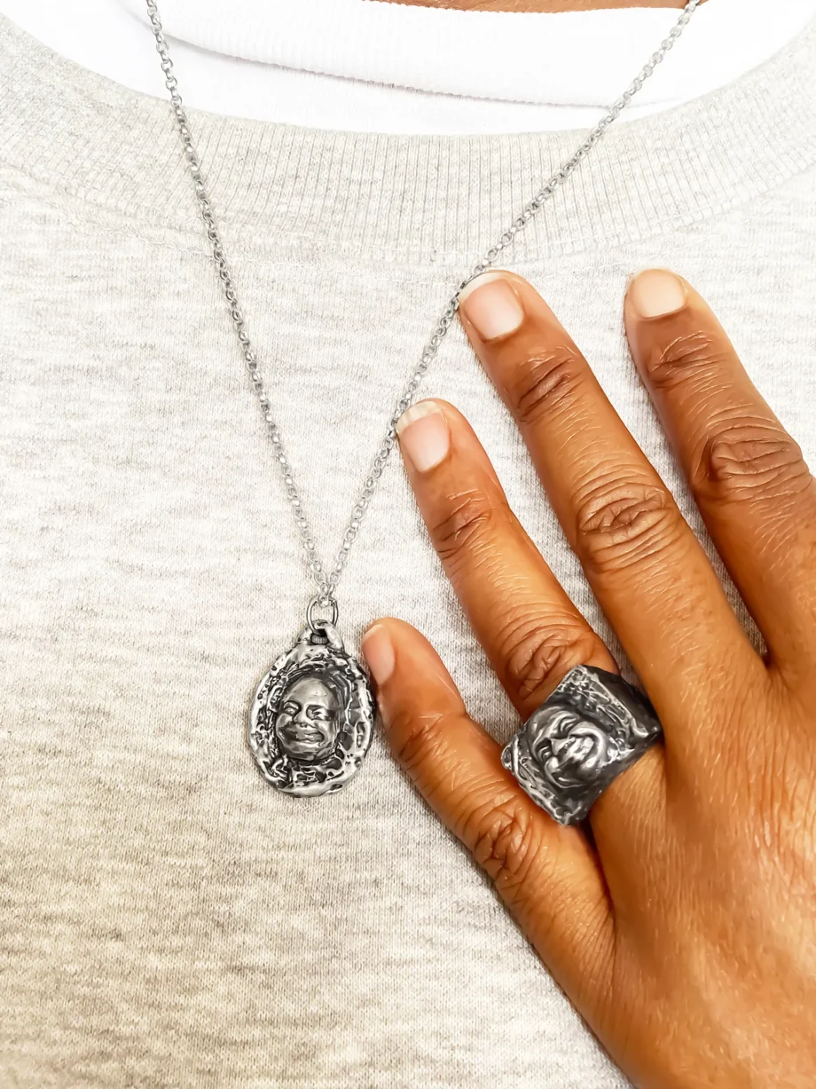 Buddha Face Pendant worn with matching ring, shown on hand and chest
