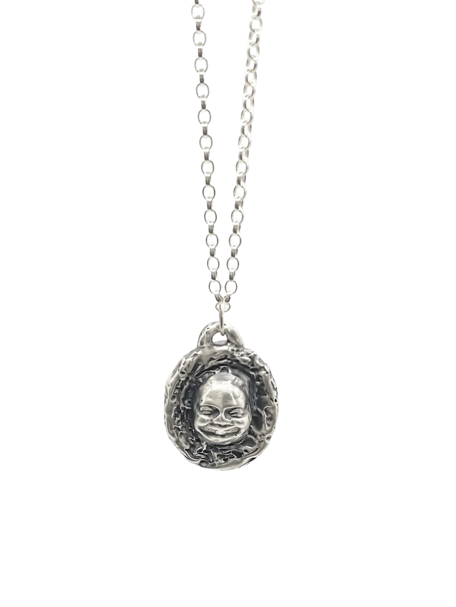 Buddha Face Pendant hanging on chain, full view against white background