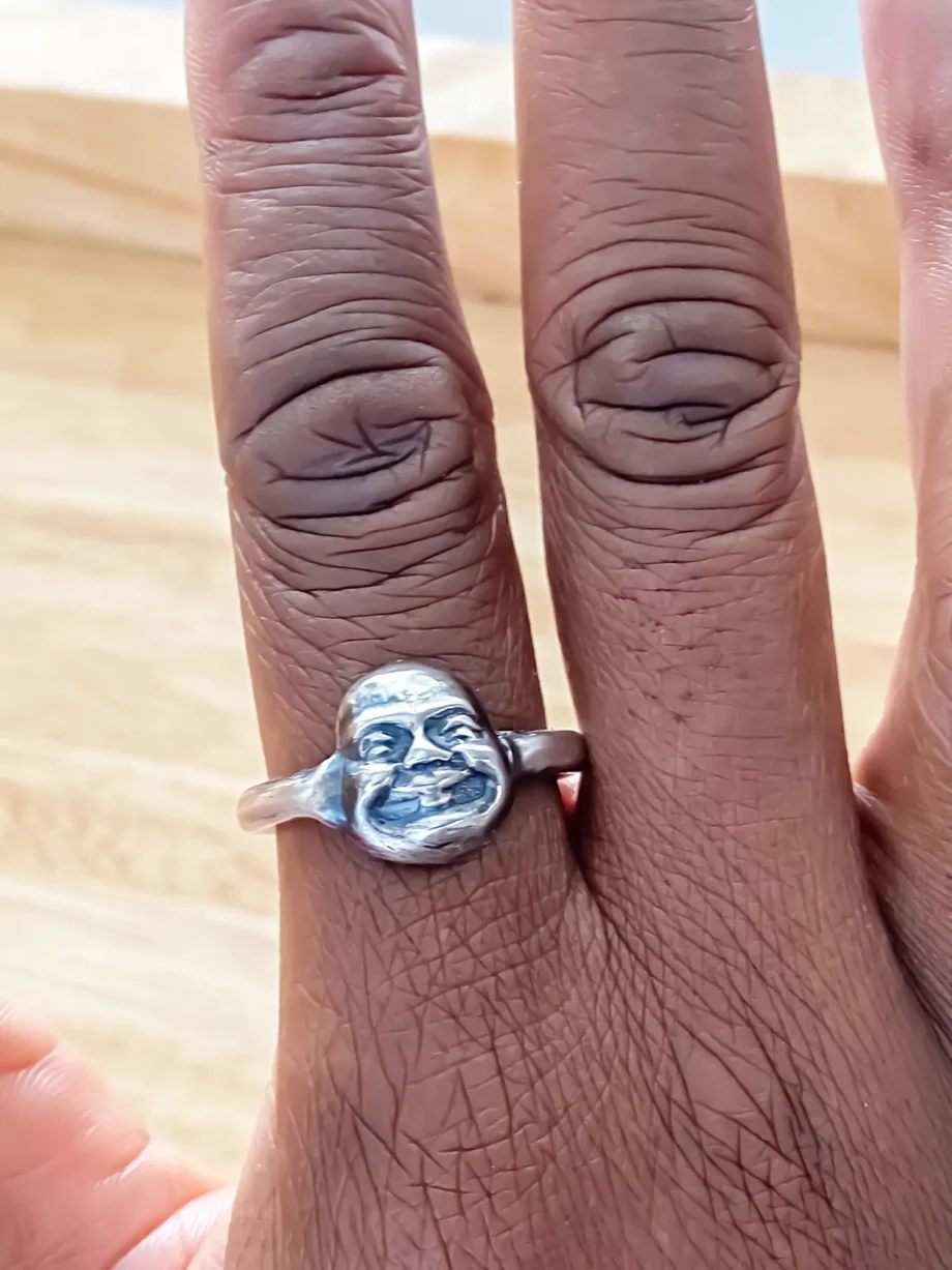 Close-up of two fingers wearing Buddha Face Rings