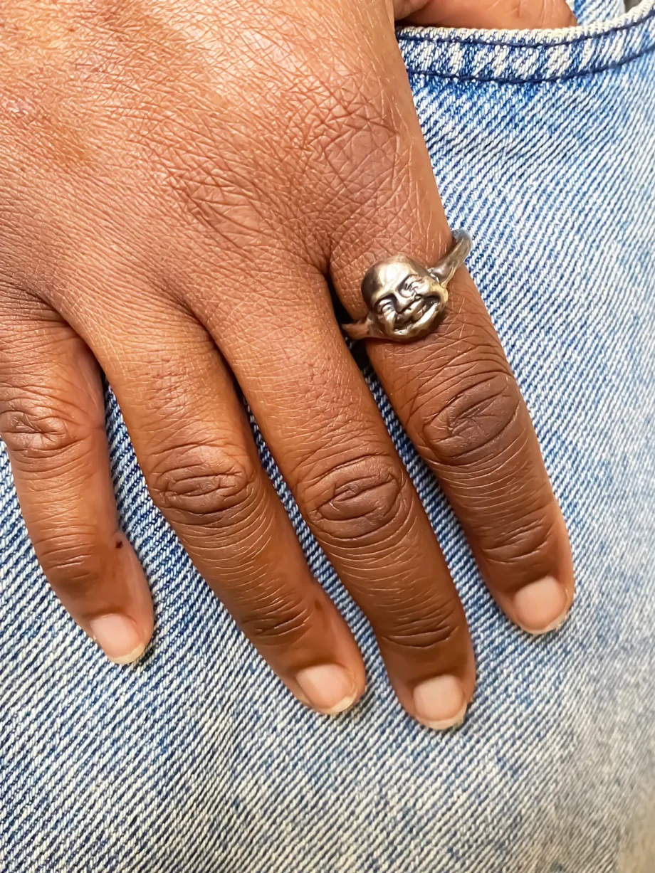 Person wearing the Buddha Face Ring on index finger