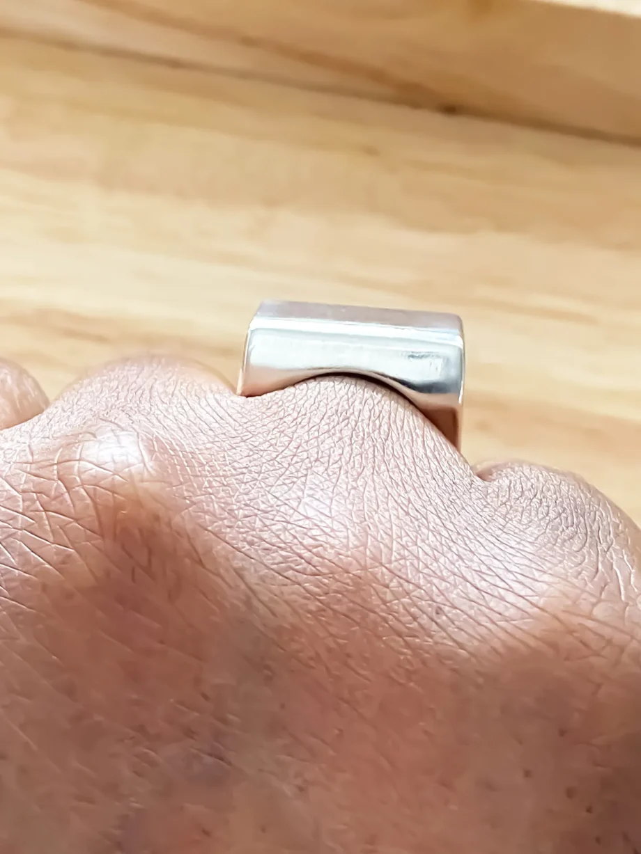 Silver block ring worn on hand, side view