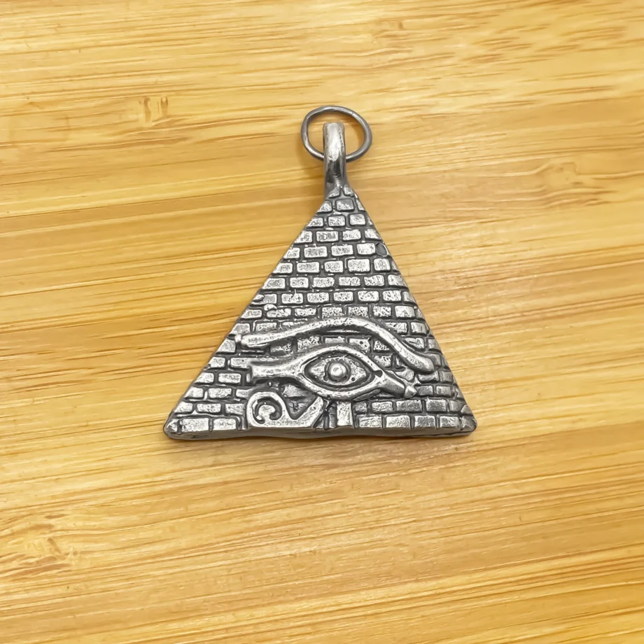 Close-up of the Horus Eye Pyramid Pendant on a wooden surface