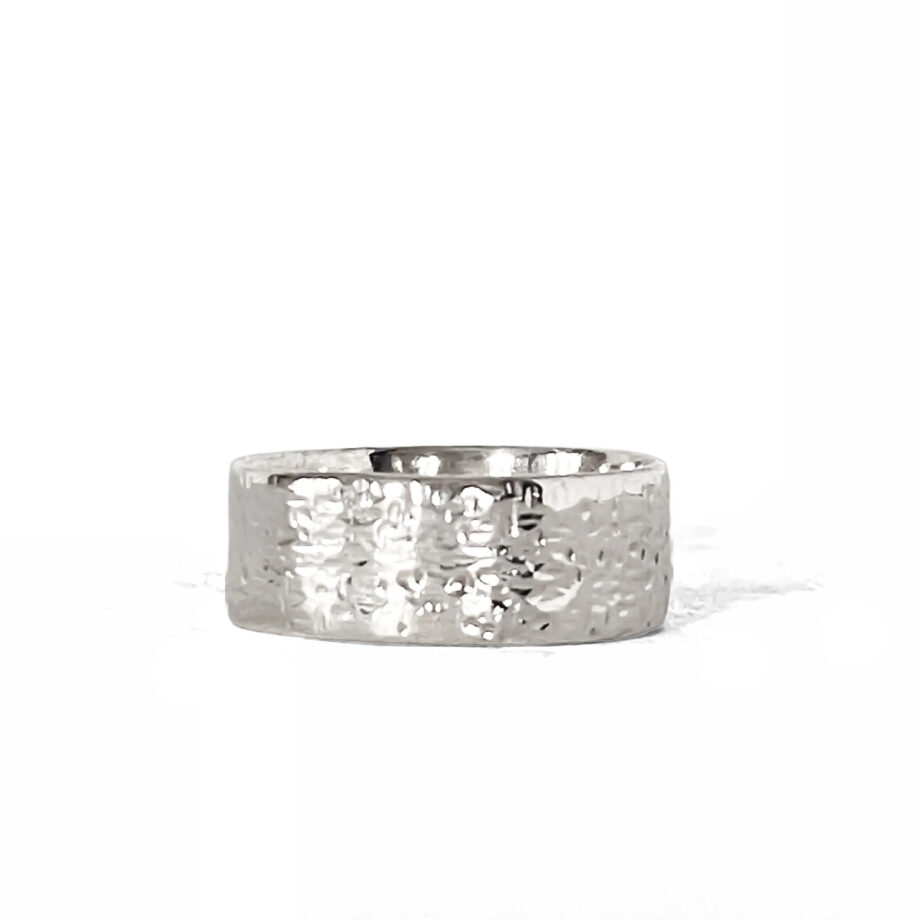 Hammered silver ring photographed on a white background, angled to show texture.