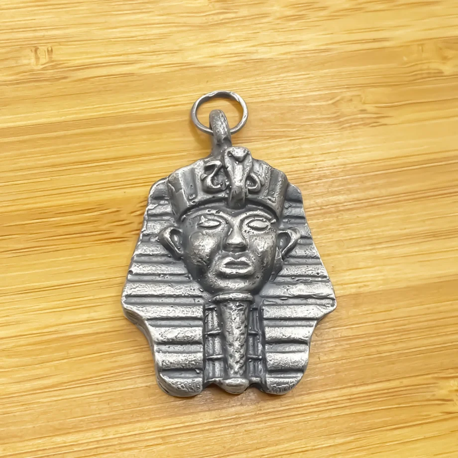 Close-up of the Pharaoh Pendant on a wooden surface.
