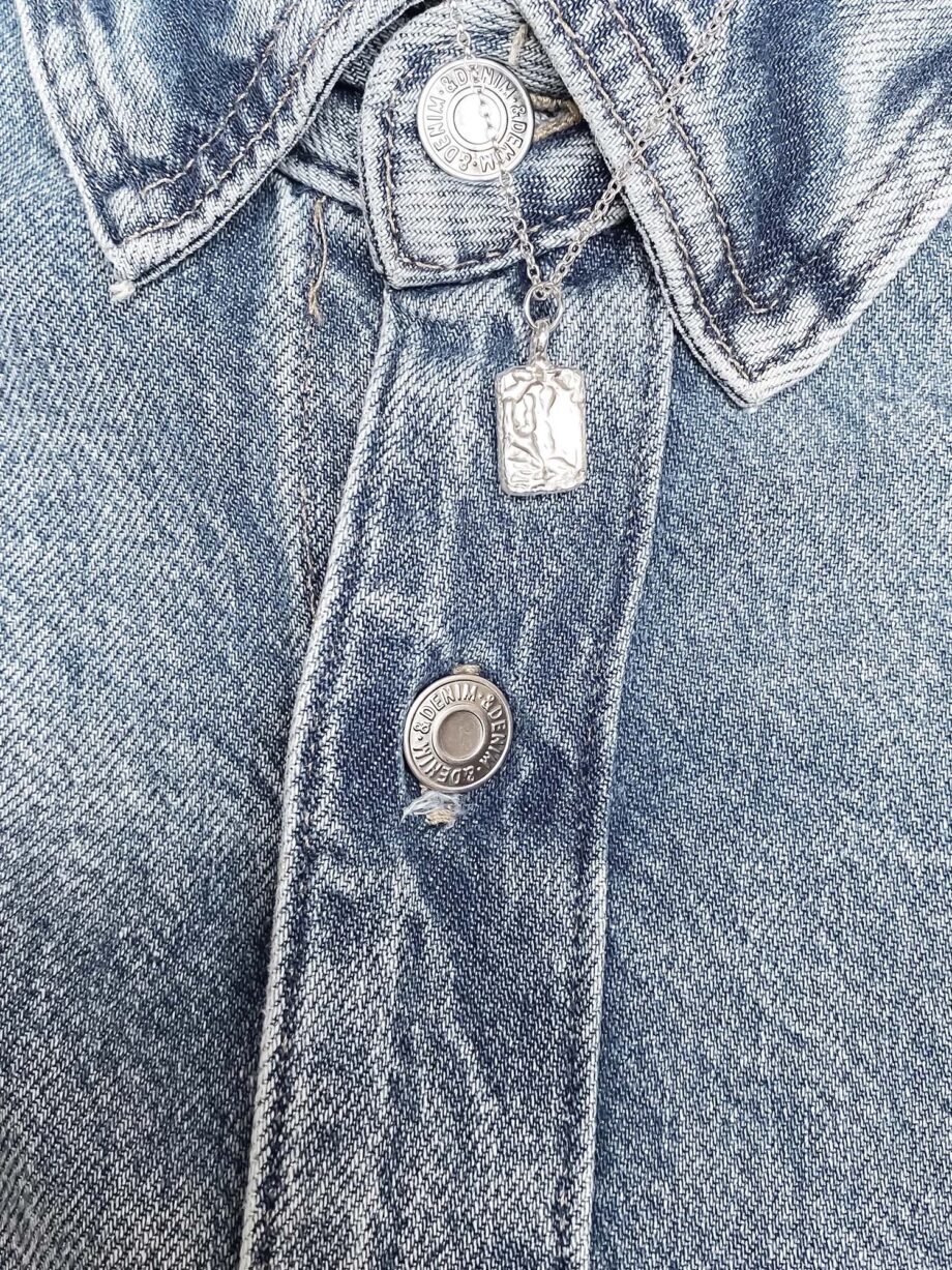 Silver rectangular pendant necklace styled with vintage denim jacket