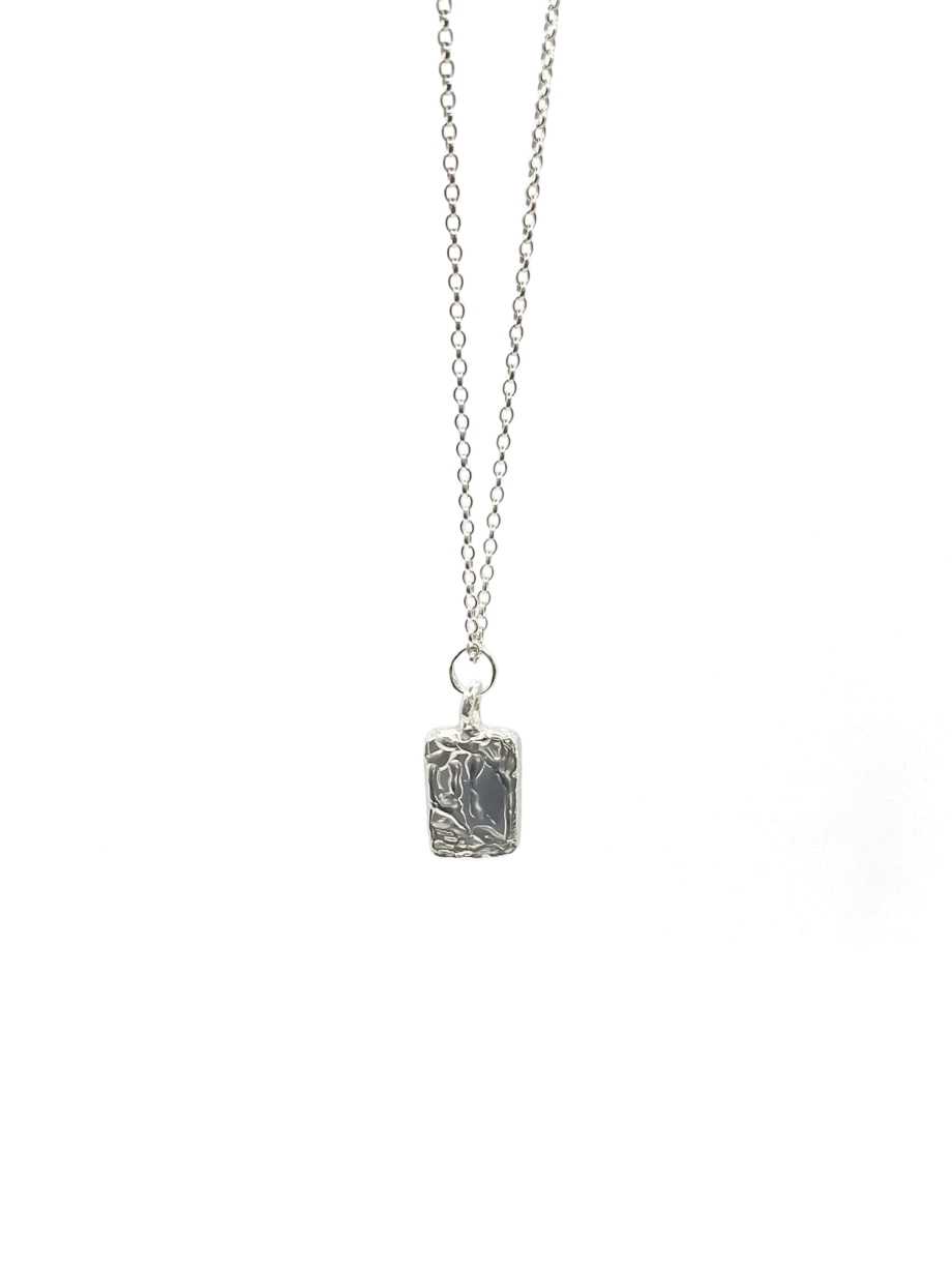 Alternative silver chain styling with rectangular pendant flat lay