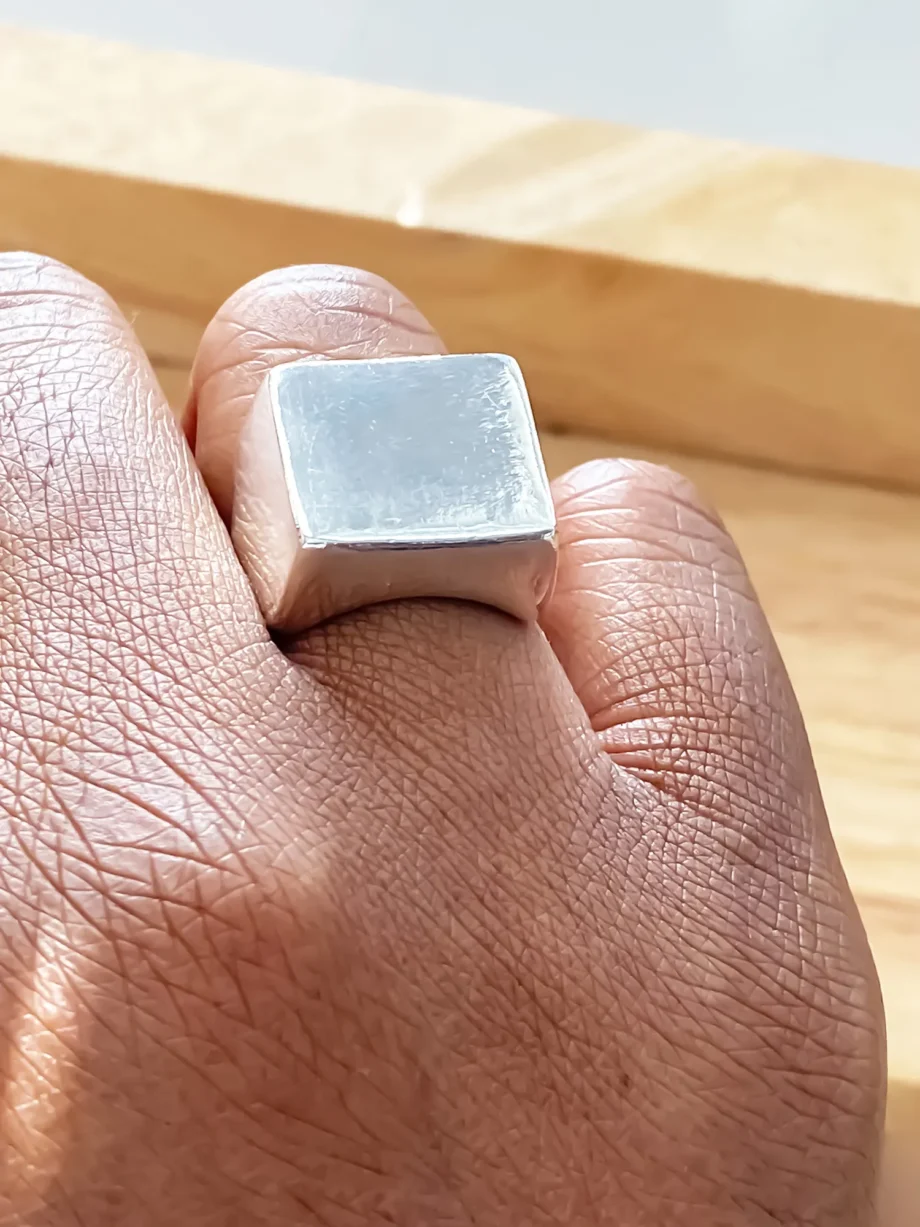 Close-up of silver square signet ring worn on finger from different perspectives