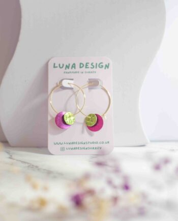 Pink and green circle-shaped leather on 30mm gold plated hoops, displayed on a neutral background
