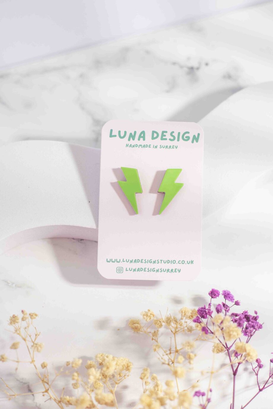 Lime green lightning bolt stud earrings with a glossy patent finish