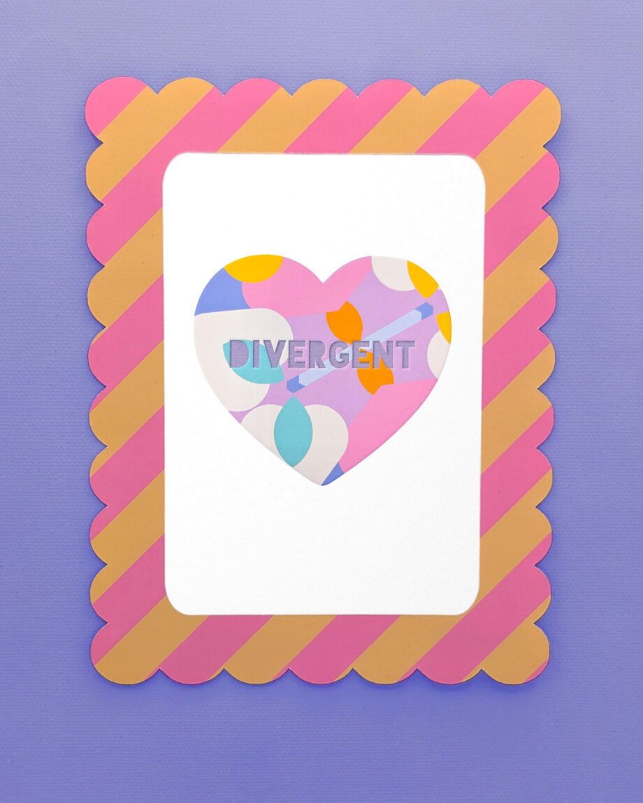 A colourful framed art print featuring a heart with the word "DIVERGENT" in block letters. The heart has a bold, abstract pattern in pink, purple, yellow, and blue. The frame is scalloped with alternating diagonal stripes of pink and gold on a purple background.