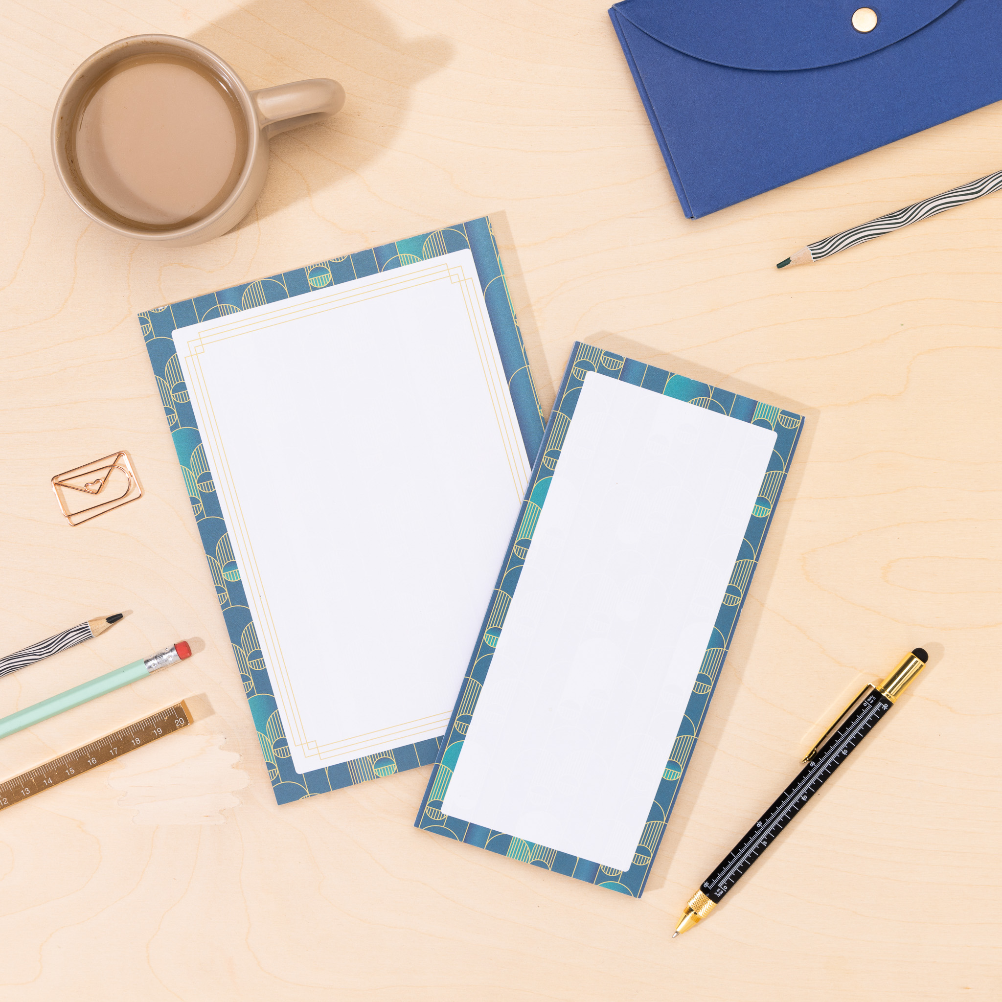 a5 notepad and DL List pad in the Deco Delights pattern and lying flat on a wooden desk top.