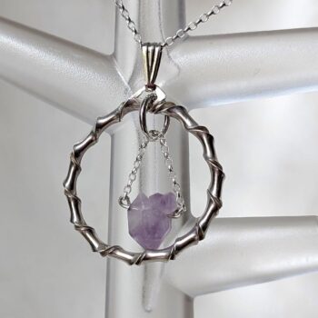 Amethyst in circular silver pendant