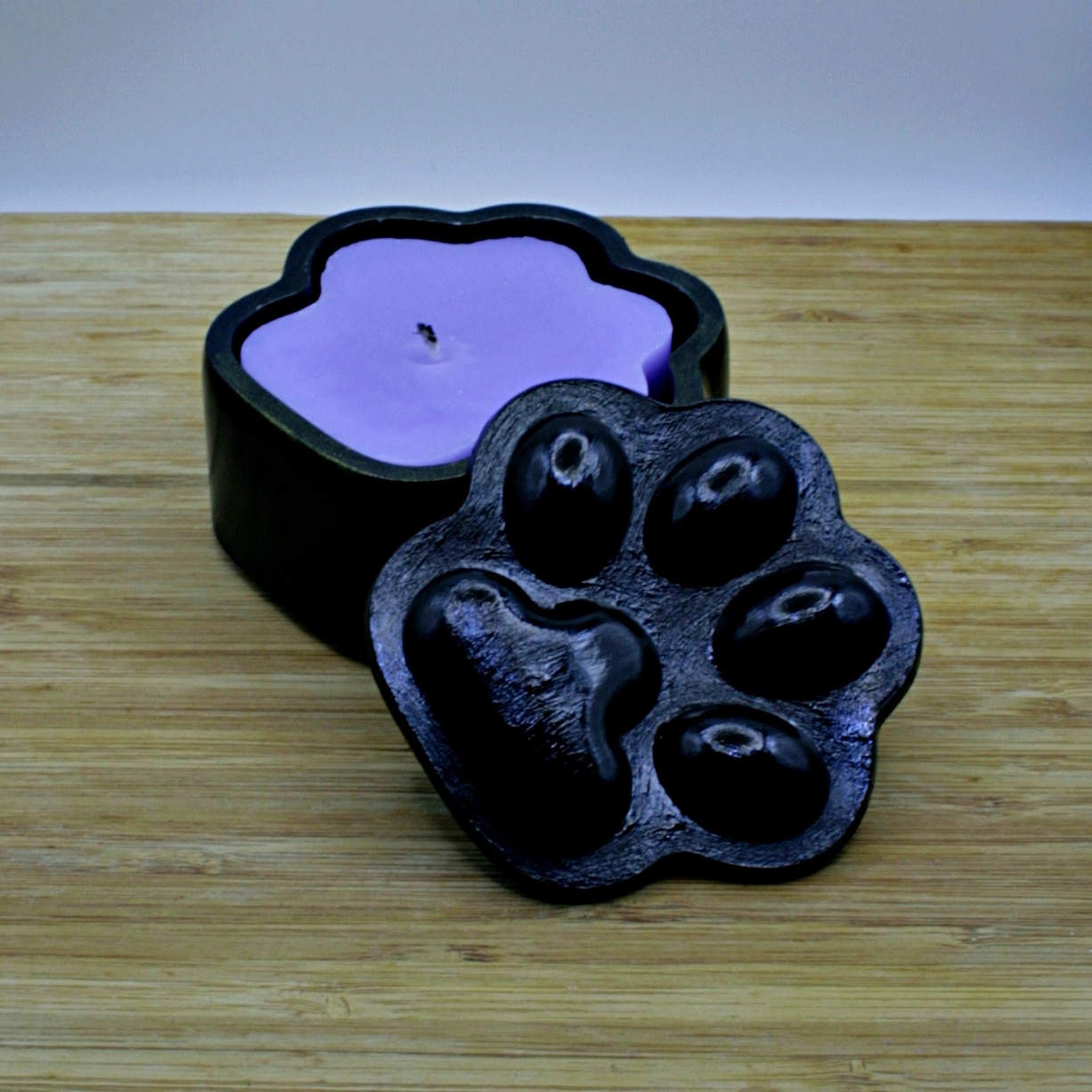 Black Paw-shaped box with a pastel purple paw-shaped violet scented candle