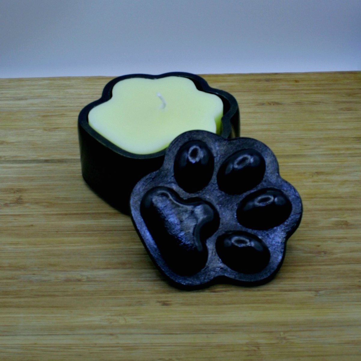 Black Paw-shaped box with a yellow paw-shaped honey scented candle
